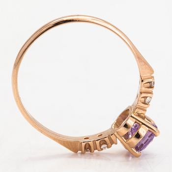 Ring, 14K guld, med en lila-rosa safir och diamanter tot. ca 0.07 ct. Kultakeskus, Tavastehus 1998.