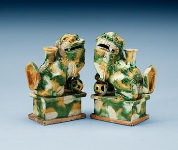 A pair of green and yellow glazed bisquit cencers, in the shape of sitting Buddhist lions, Qing Dynasty, Kangxi (1662-1722).