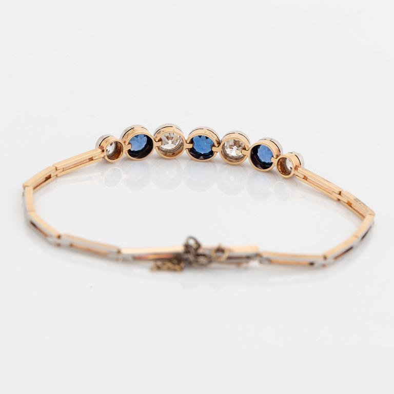 An 18K gold bracelet set with sapphires and old-cut diamonds.