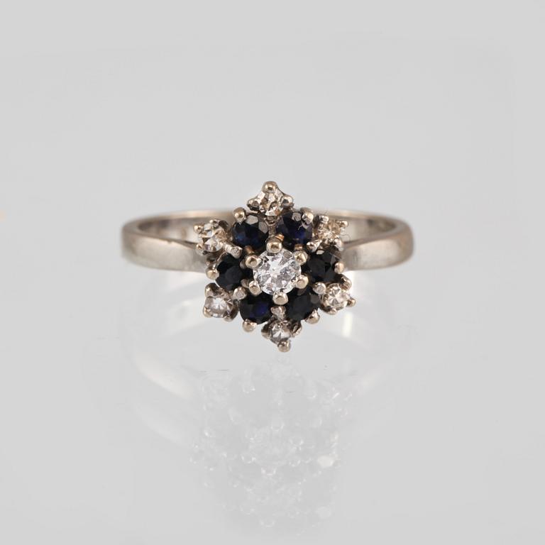 RING, 18K vitguld med en briljantslipad och 6 åttkantslipade diamanter och 6 fasettslipade blåsafirer. Vikt 3,9 gram.