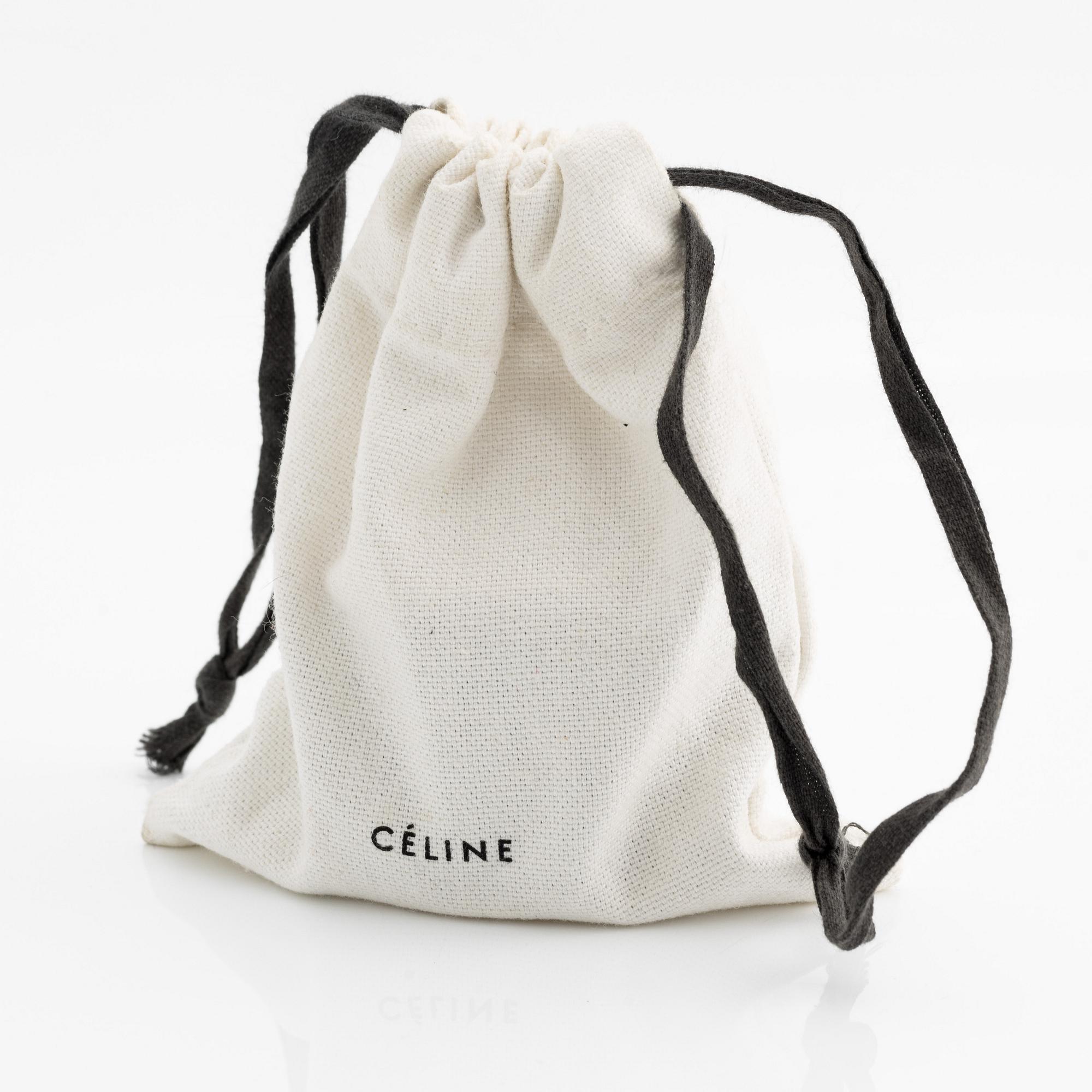 Céline, armring, guldfärgad metall och skinn.