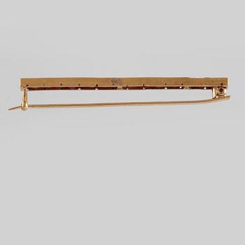BROSCH, 18K guld med 15 fasettslipade rubiner. Vikt 4,8 gram.