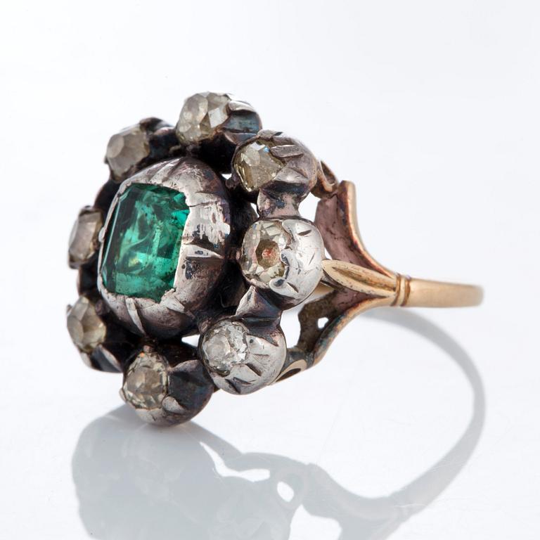 A ring set with an emerald and old-cut diamonds.