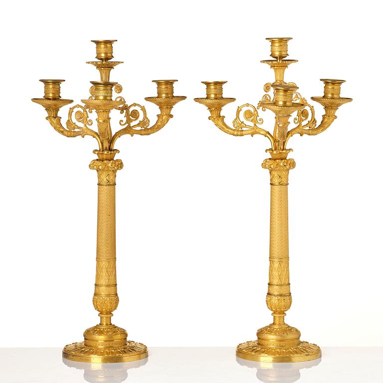 A pair of French Empire four-light gilt bronze candelabra, early 19th century.
