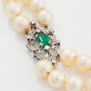 A two strand cultured pearl necklace clasp in 18K white gold set with a faceted emerald.