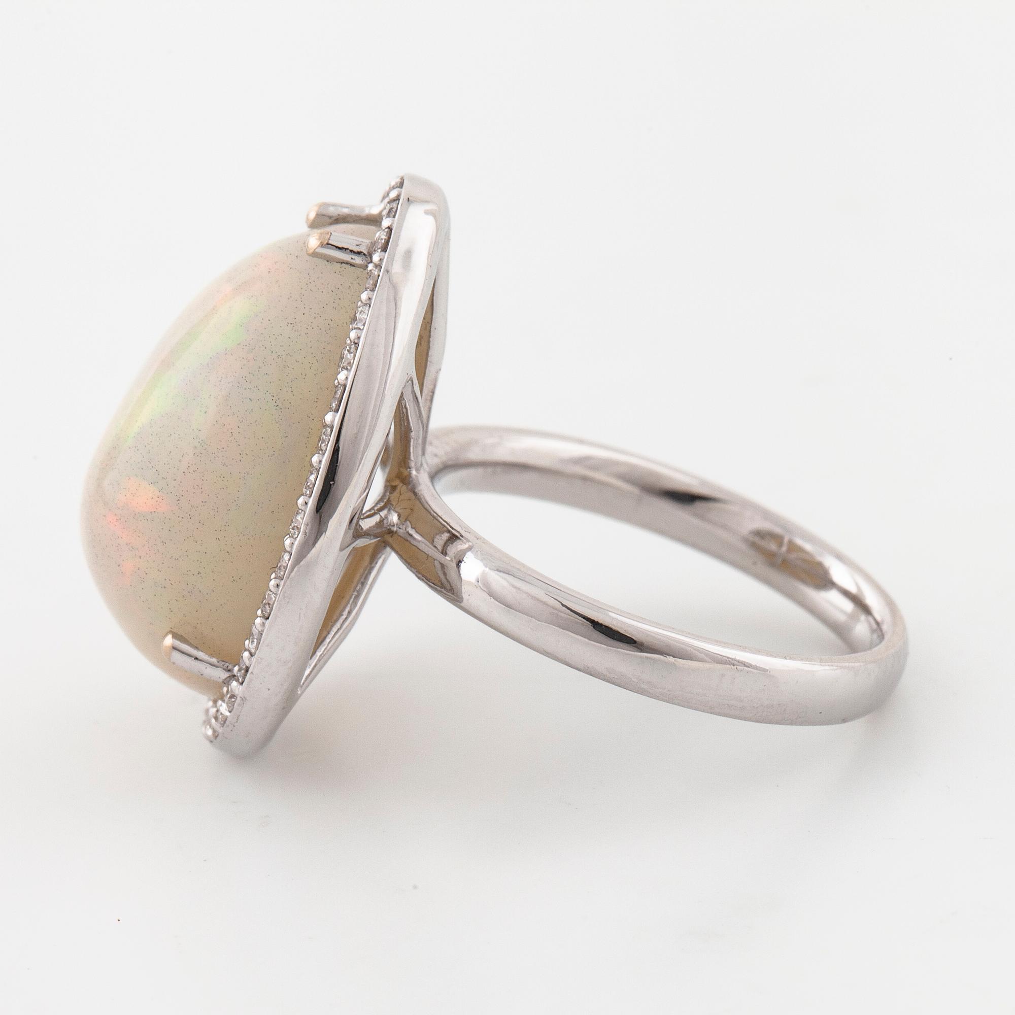 A cabochon cut white opal and a brilliant cut diamond ring.