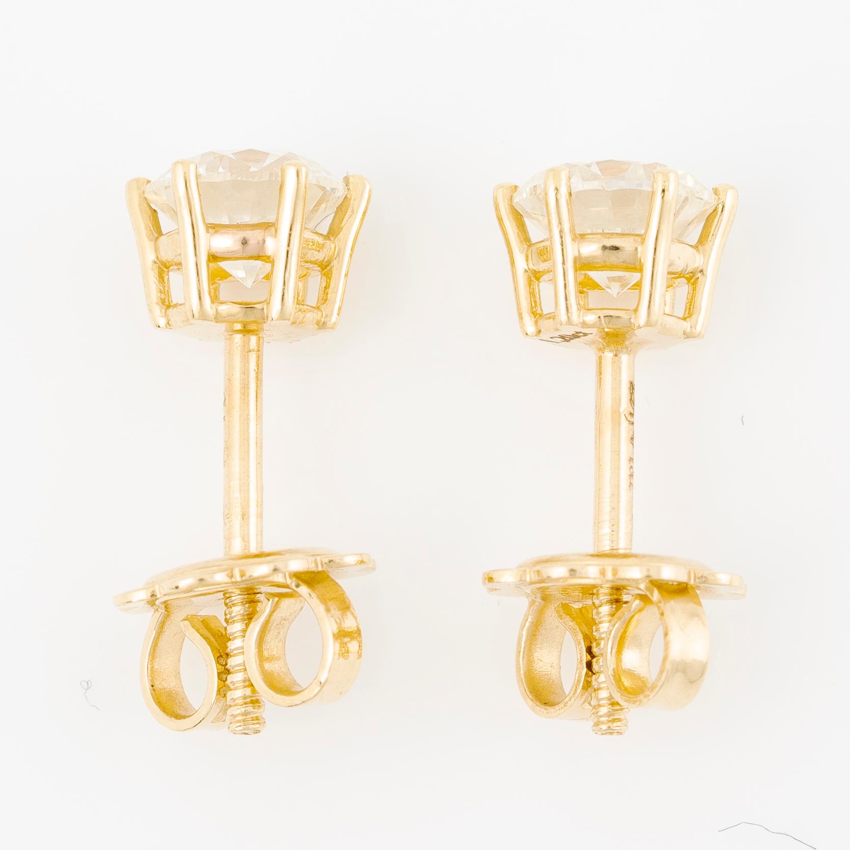 A pair of earrings in 18K gold set with two round brilliant-cut diamonds.