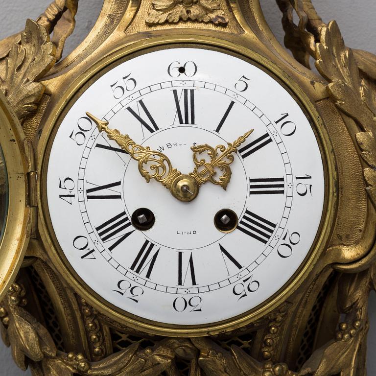 A brass wall clock marked A.W. Bruuns eftr, Lund from around year 1900.