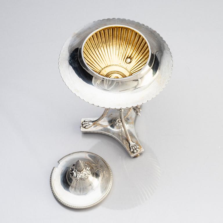 A Swedish Empire silver sugar bowl with lid and a suger sprinkle spoon, marks of Adolf Zethelius, Stockholm 1819.
