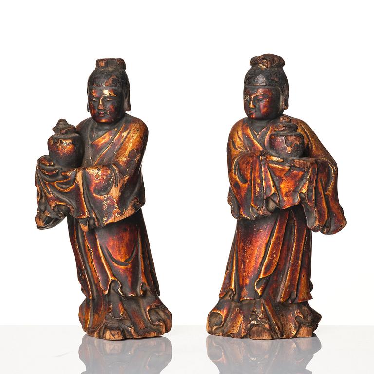 A pair of wooden gilt lacqer figures of officials carrying vases, 17/18th century.