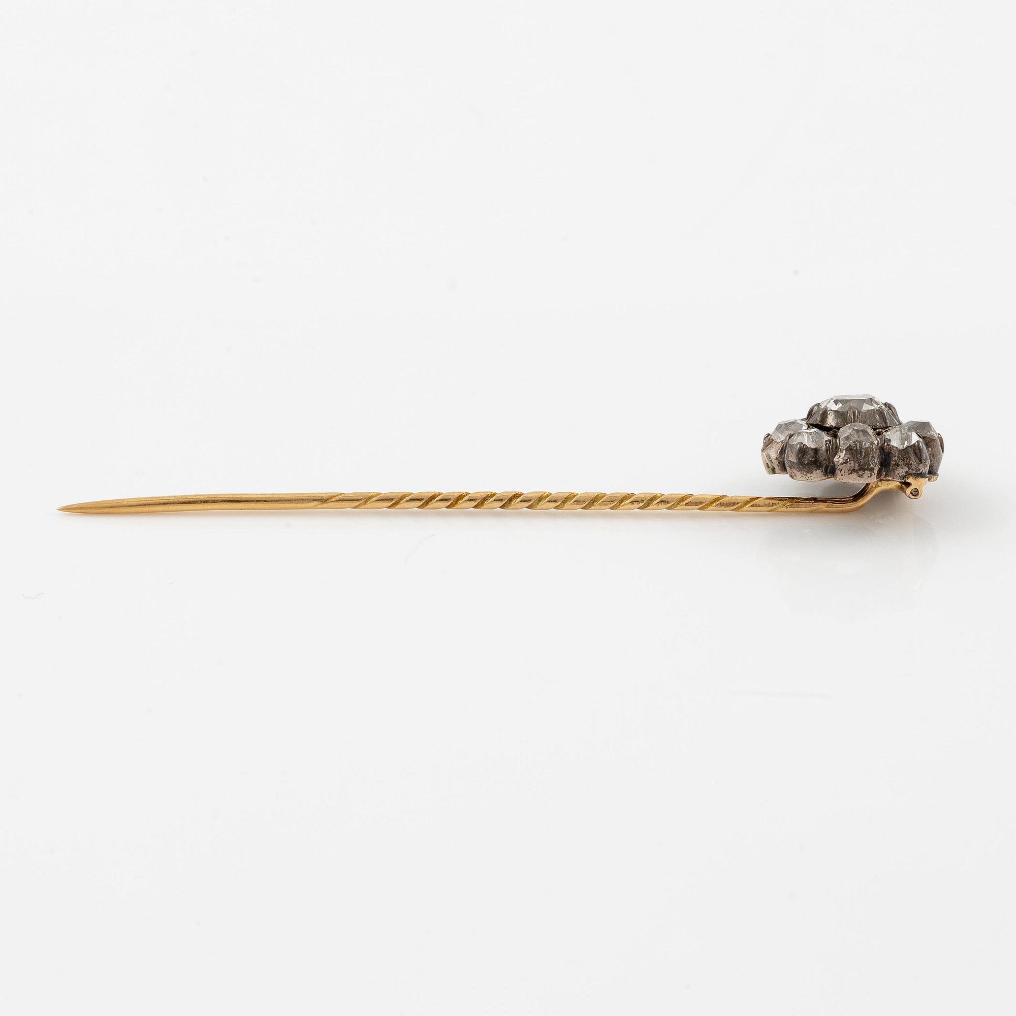 A brooch/pin in 18K gold silver with old-cut diamonds.