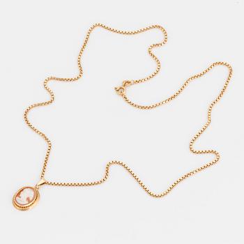 An 18K gold chain and pendant set with a shell cameo.