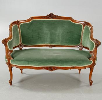 A rococo style sofa, two lounge chairs and a table, around the year 1900 and first half of the 20th century.