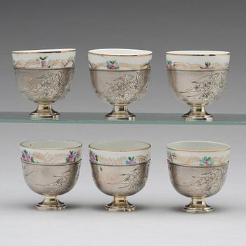 A set of six Ottoman parcel-gilt silver Xarfs with Russian Kuznetzov porcelain cups, c. 1910.