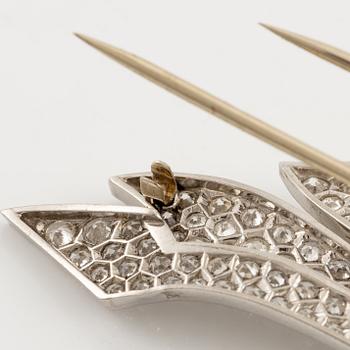 A brooch in platinum in the form of a bow with rubies and diamonds, likely from the 1950s.