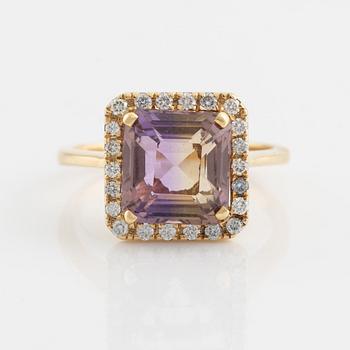 An 18K gold and ametrine ring set with round brilliant-cut diamonds.