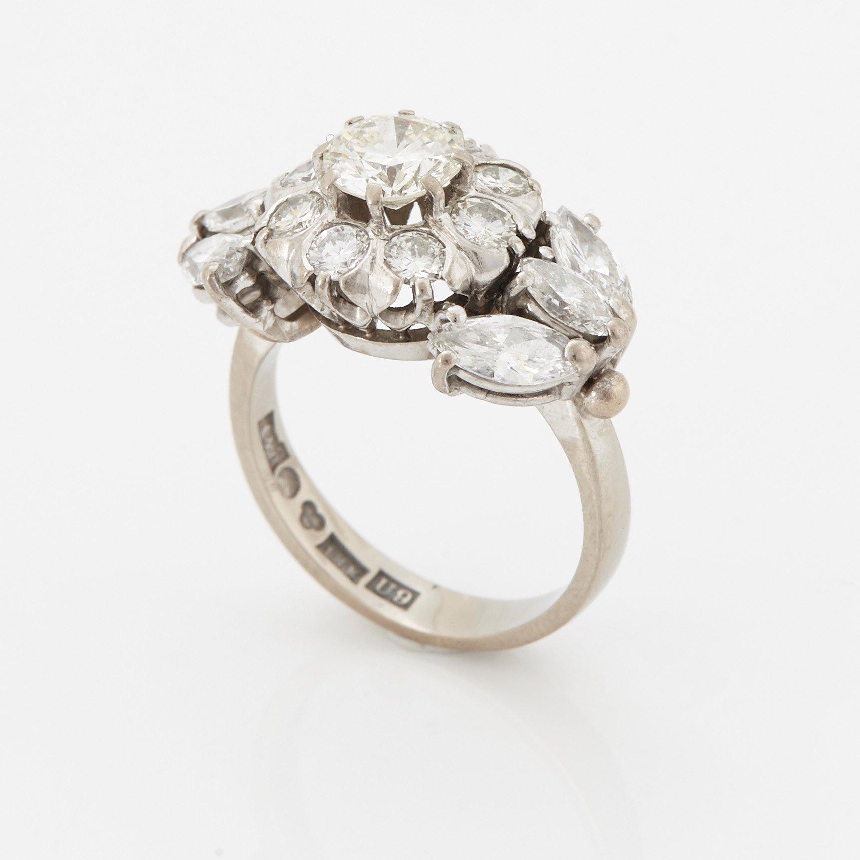 An 18K white gold ring set with round brilliant- and navette-cut diamonds.