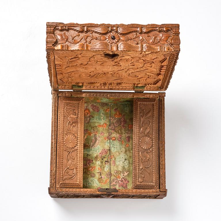 A baroque wedding casket, carved wood, dated 1725.