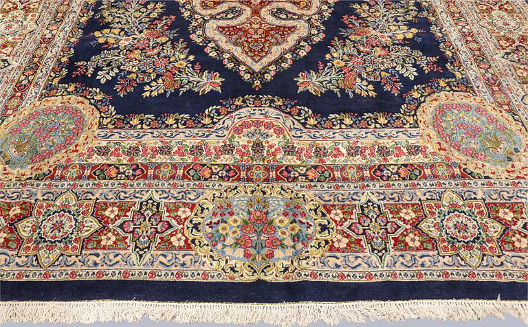 A semi-antique Kirman Laver carpet, 'Millefleur', signed, approx. 427 x 309 cm.