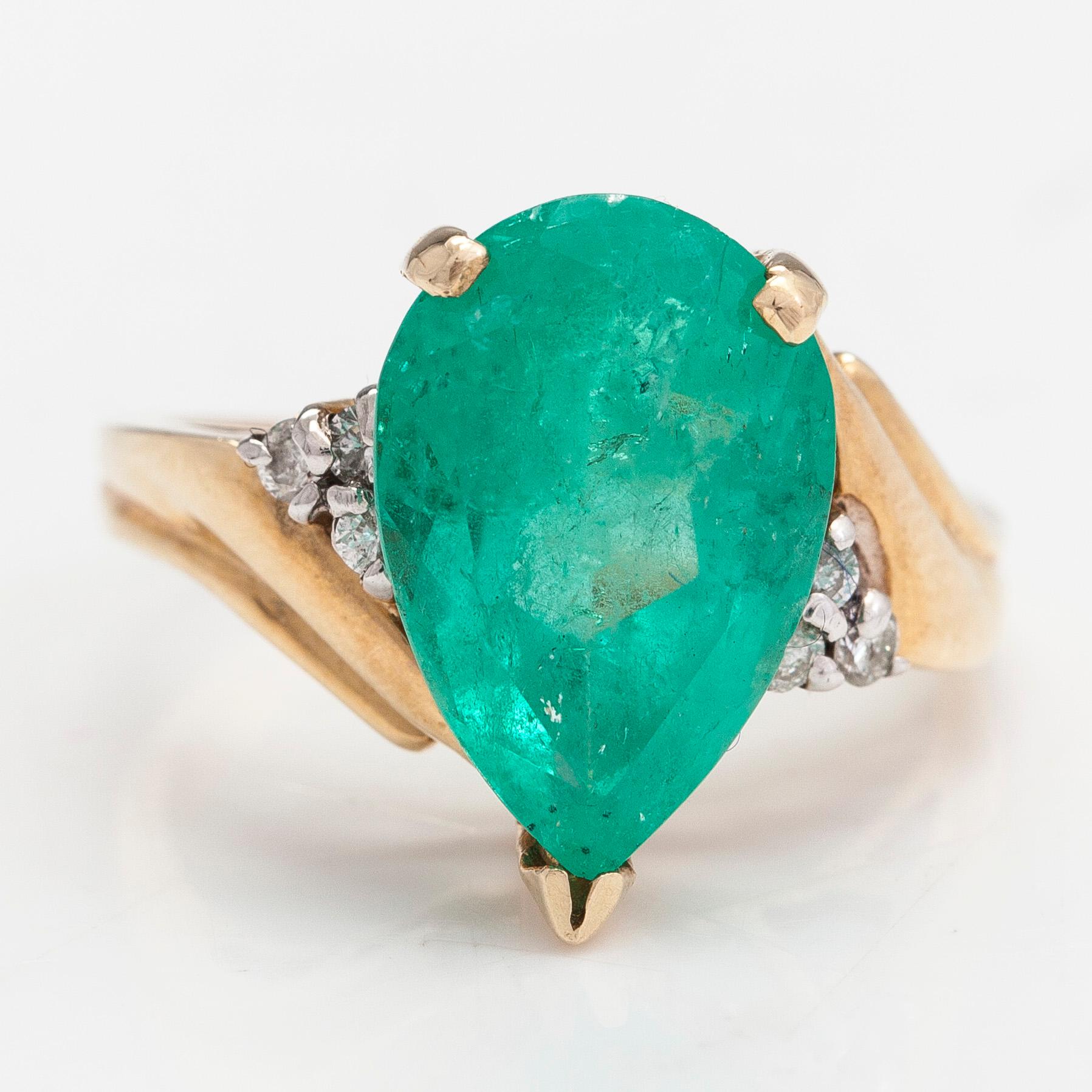 Ring, ca 10-11K gold with a pear shaped emerald and diamonds approx 0.10 ct in total.