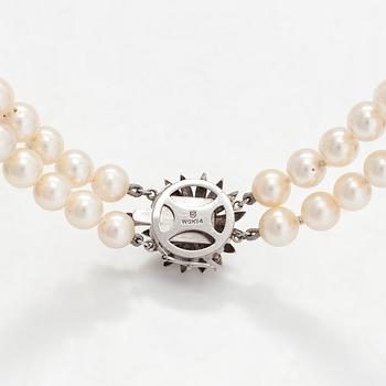 A double-stranded necklace, with cultured Akoya pearls, clasp in 14K white gold with brilliant-cut diamonds. With certif.