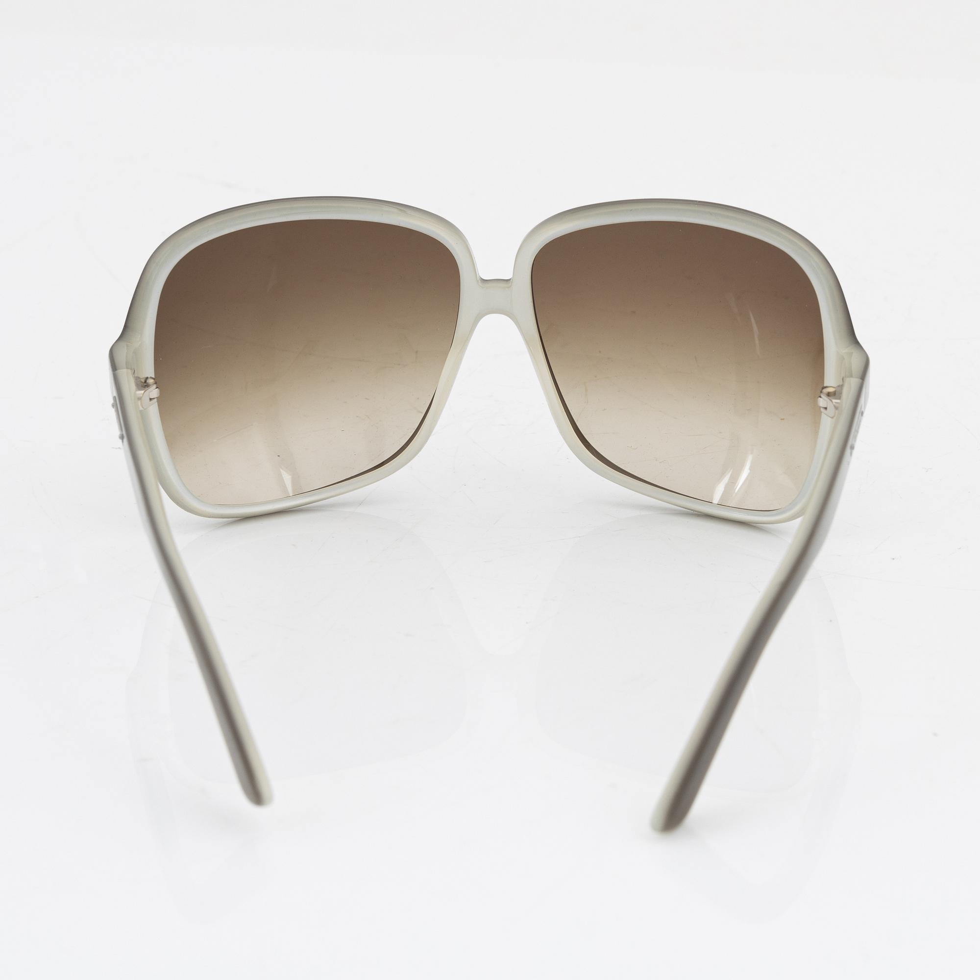Yves Saint Laurent, a pair of grey plastic sunglasses.
