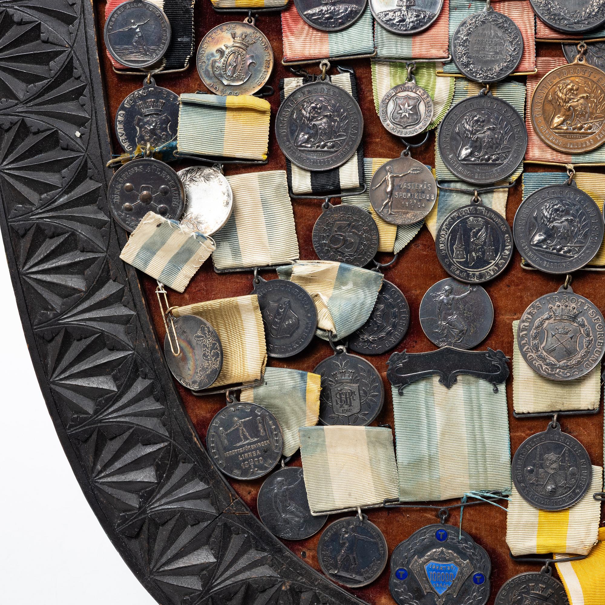 Idrottsmedaljer på märkessköld. Delvis silver. Sverige 1900-talets första hälft.