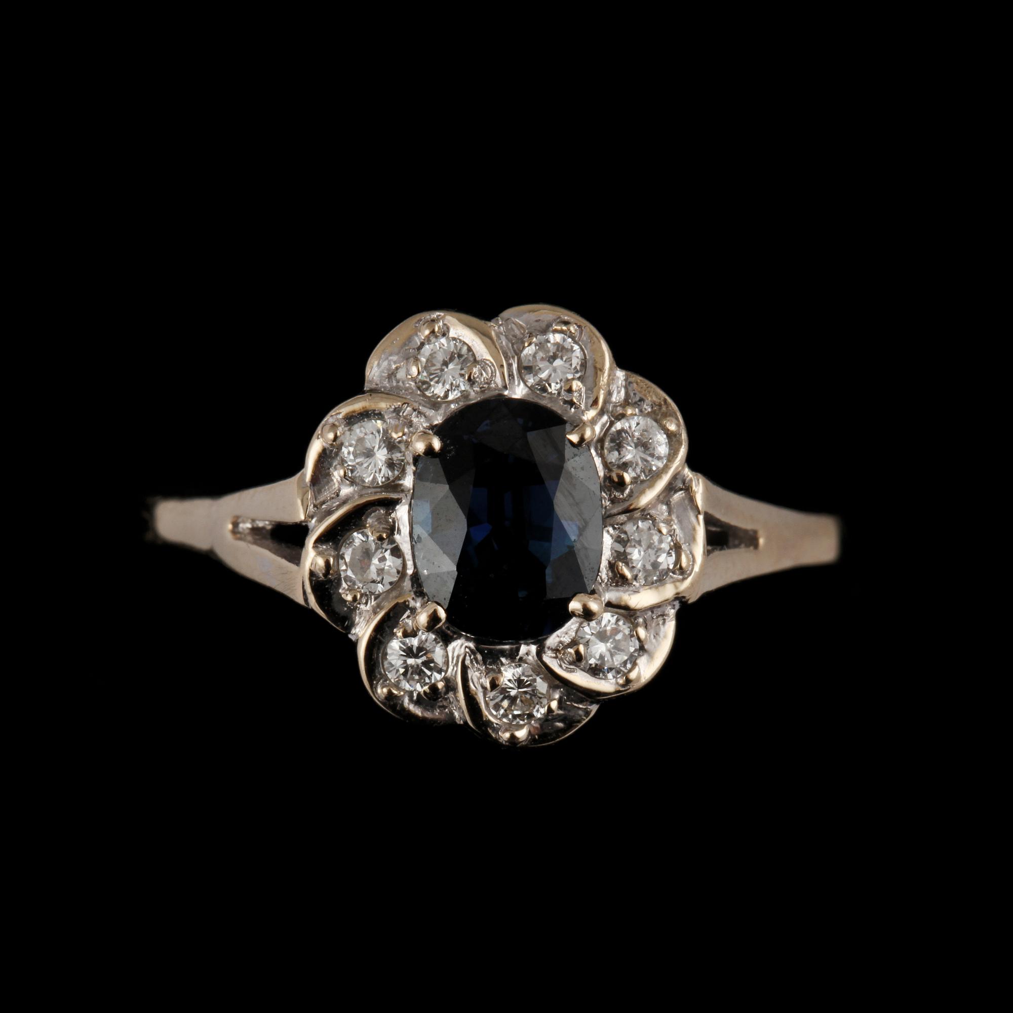 RING, 18k vitguld med 9 briljantslipade diamanter, 0.12 ct samt fasettslipad blå safir, importstämplad. Vikt 3 g.