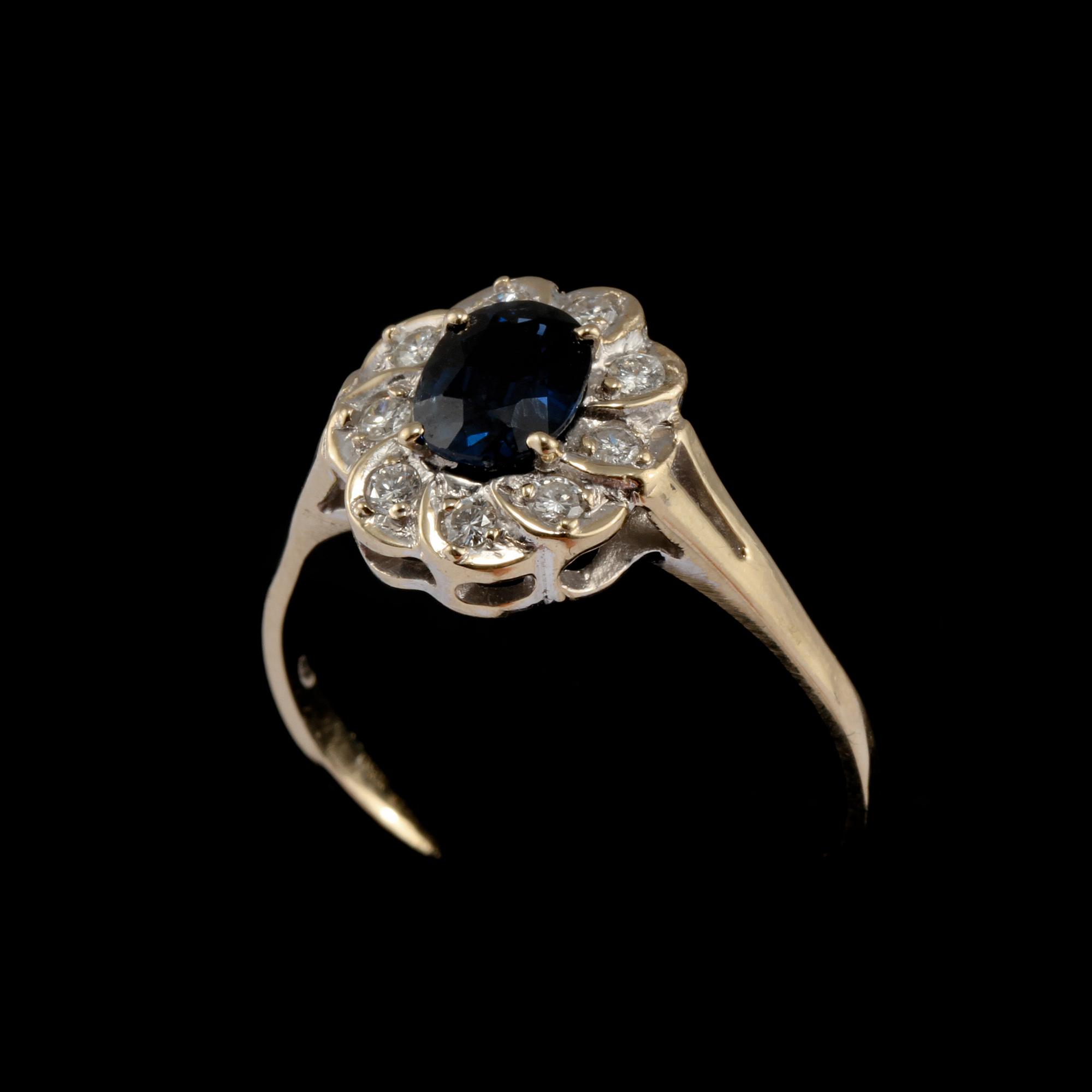 RING, 18k vitguld med 9 briljantslipade diamanter, 0.12 ct samt fasettslipad blå safir, importstämplad. Vikt 3 g.