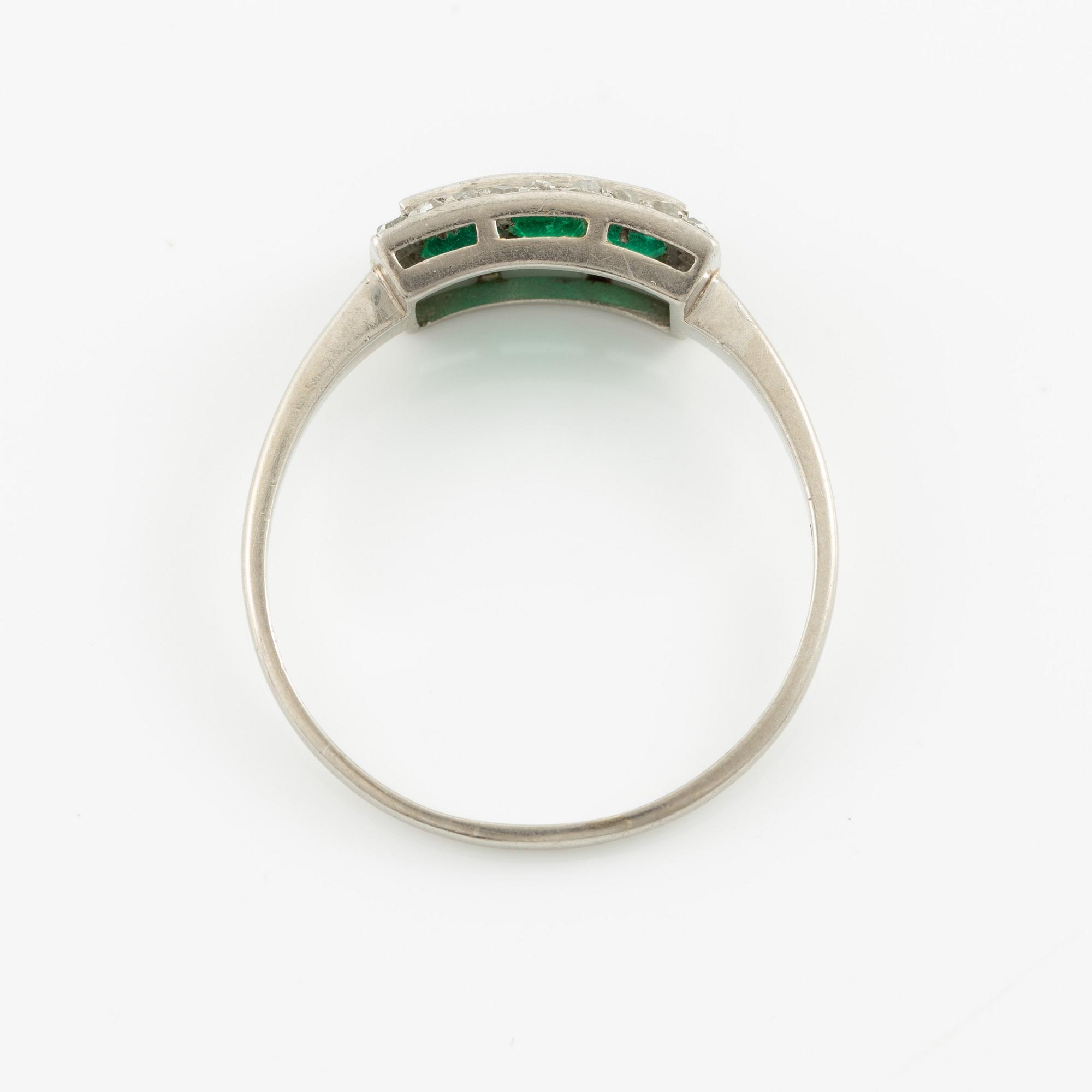 Ring in platinum set with step-cut emeralds and rose-cut diamonds.
