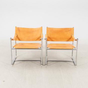 A pair of metal and leather arm chairs by DUX.