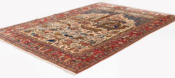 A signed semi-antique pictoral part silk Qum carpet, c. 341 x 224 cm.