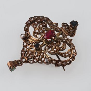 HÄNGE/BROSCH, silver med rosensliapde diamanter samt fasettslipade blå safirer, syntetisk rubin och smaragd. Vikt 9,1 g.