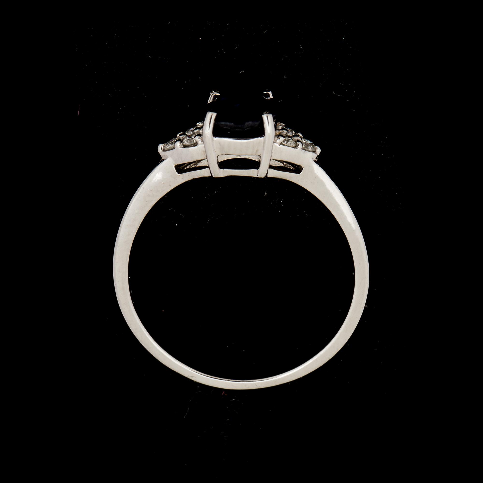 RING, 14 k vitguld med safir ca 1,32 ct, samt 6 mindre briljantslipade diamanter ca 0,06 ct. Vikt ca 2 g.
