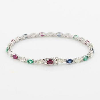 Bracelet 18K white gold set with faceted rubies, emeralds, sapphires, and round brilliant-cut diamonds.