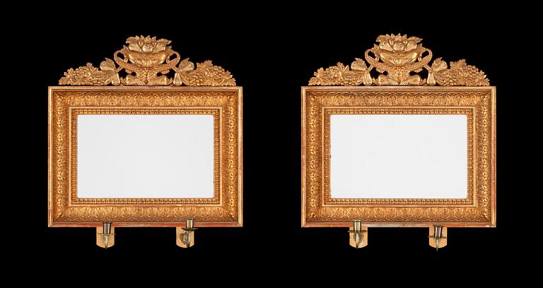 A pair of Swedish Empire first half 19th century two-light girandole mirrors.