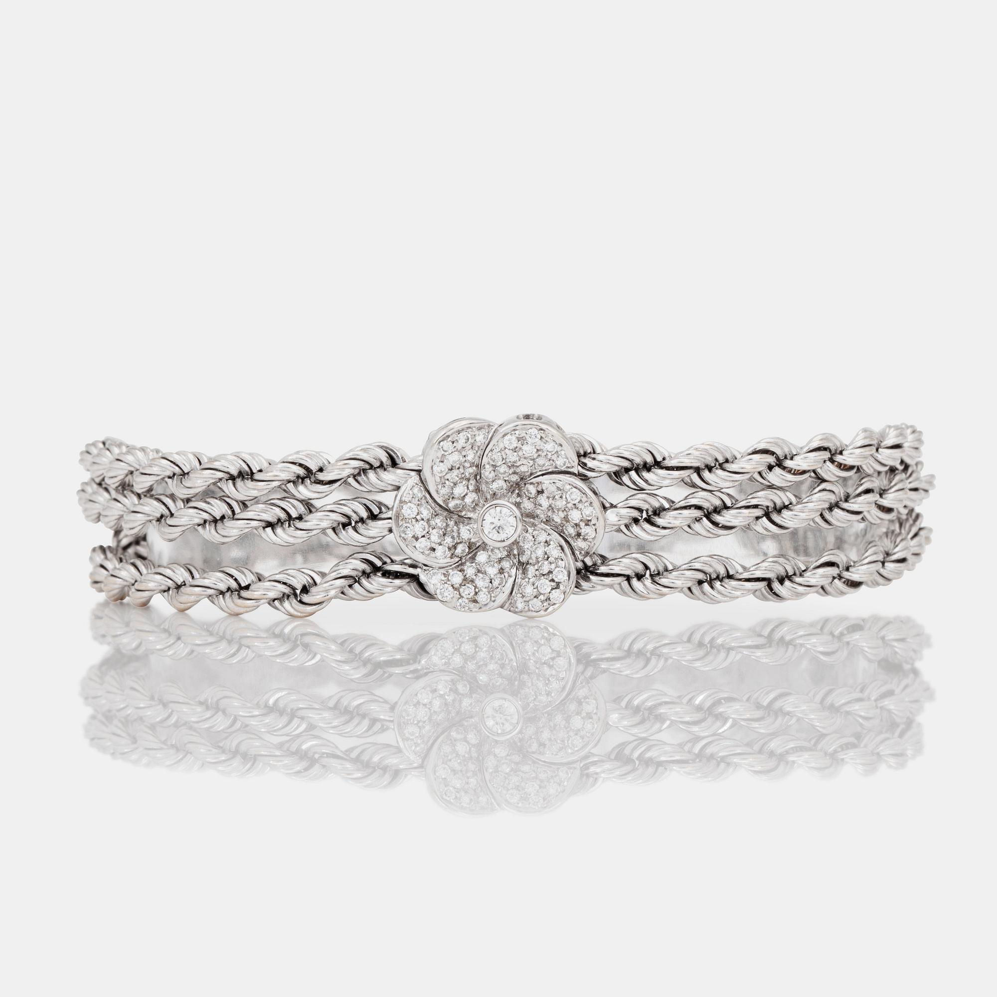 ARMBAND med tre stycken diamantklädda blommor.