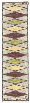 A flat weave runner, c 278 x 76 cm, signed DE.