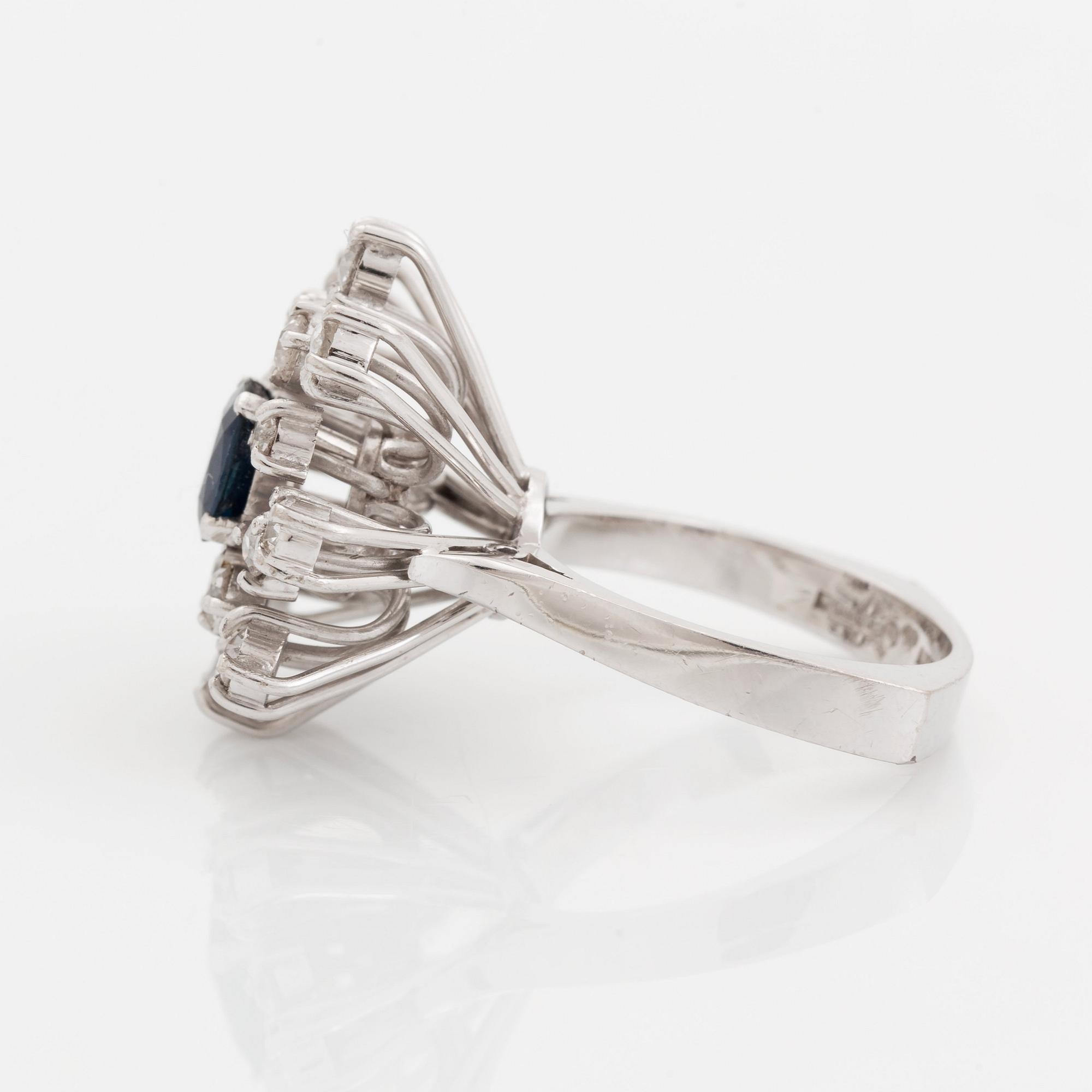 An 18K white gold ring set with a faceted sapphire and old-cut diamonds.