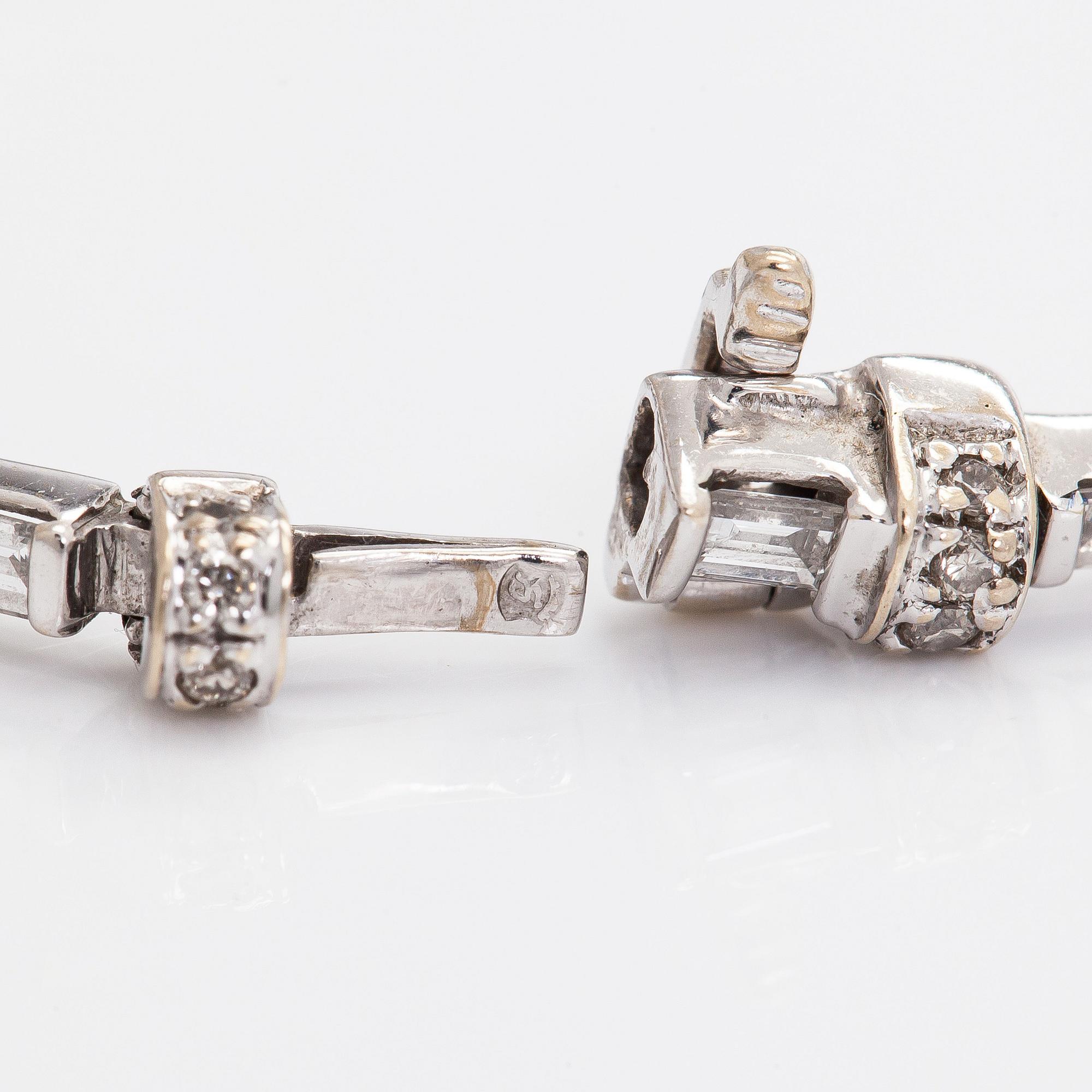 An 18K white gold bracelet set with baguette and brilliant-cut diamonds.
