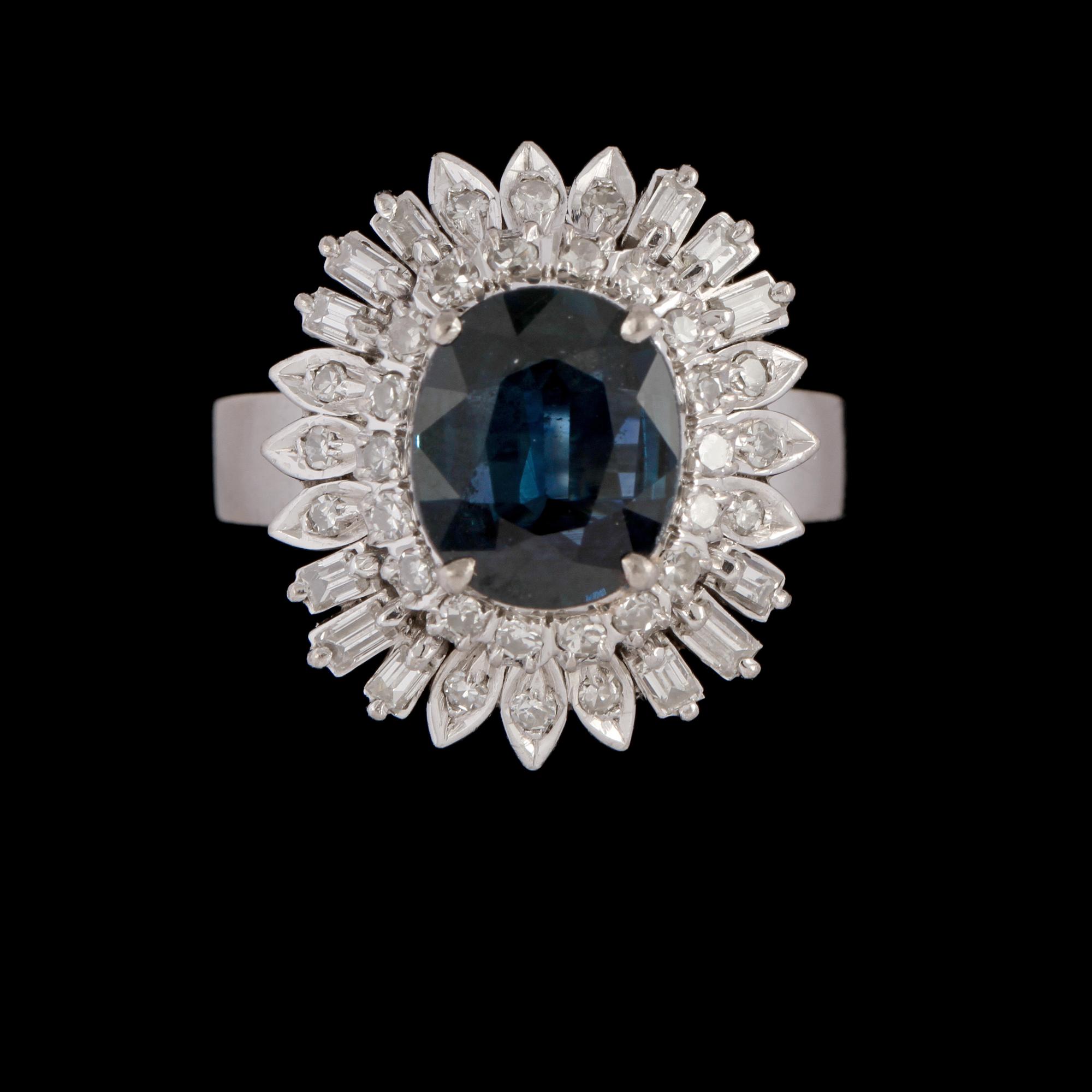 RING, 18K vitguld med ovalslipad syntetisk blå safir samt åttkant och baguettslipade diamanter. Vikt 6,8 g.
