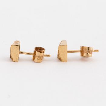 A pair of earrings with a textured surface.