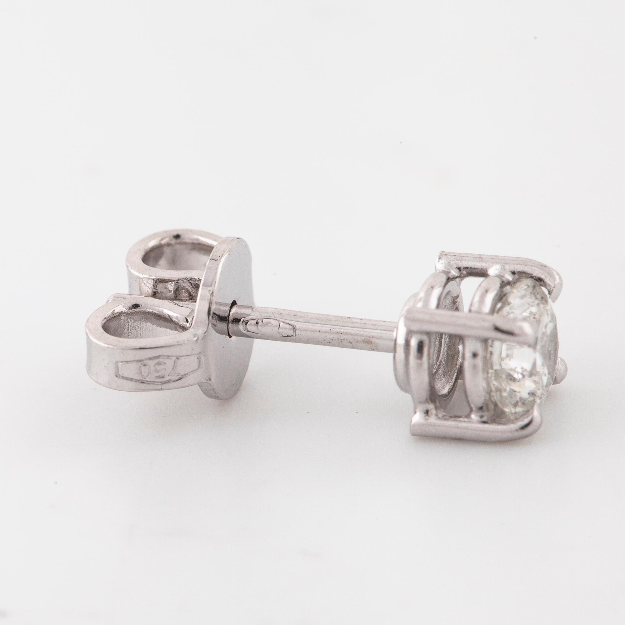 A pair of brilliant cut diamond earrings.