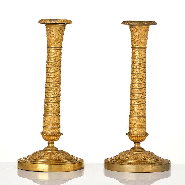 A pair of French Empire ormolu candlesticks, early 19th century.