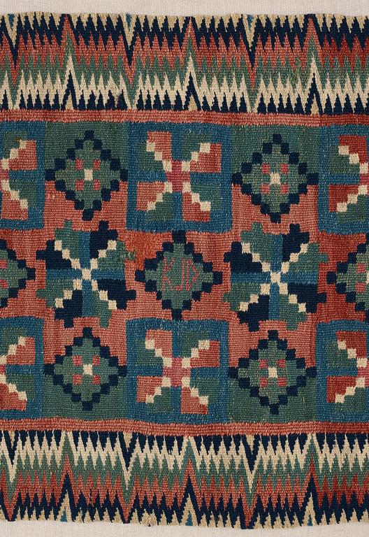 A CARRIAGE CUSHION, double-interlocked tapestry, "Åttabladsstjärnor", ca 46,5 x 104 cm, Scania (Sweden) around 1800.