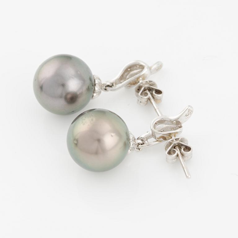 A pair of 18K gold earrings with cultured Tahitian pearls and white stones.