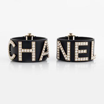 Chanel, a pair of black leather and rhinestone bracelets.