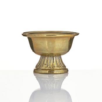 A bronze deity and a brass sacrificial bowl, Tibet, circa 1900.