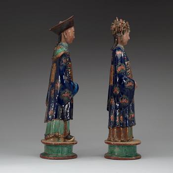 A pair of pottery figures of a Chinese official and his lady, Qing dynasty.