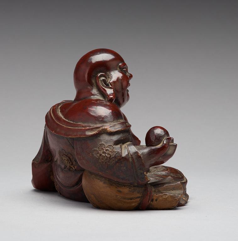 A seated wooden figure of Buddai, Qing dynasty, circa 1900.
